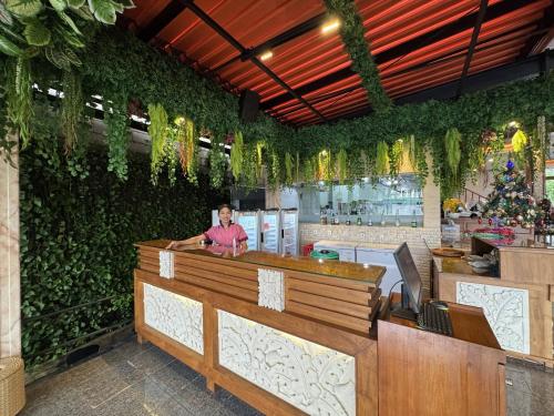 a man sitting at a counter in a restaurant at Green Garden Hotel in Kuta