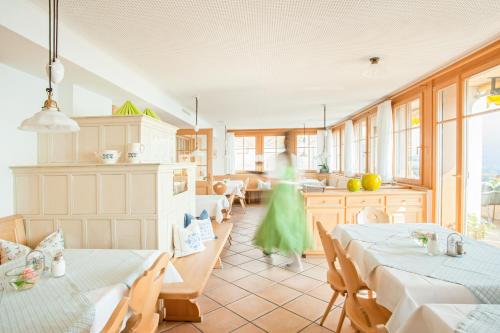 Habitación con 2 mesas y cocina con ventanas. en Hotel Dreiländerblick Dornbirn en Dornbirn