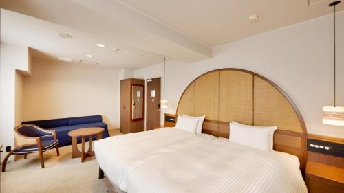 a hotel room with a bed and a table and chairs at Hotel Palm Royal Resort Kokusai Street in Naha