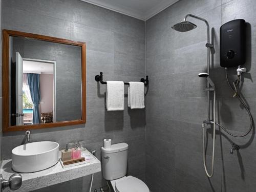 a bathroom with a shower and a toilet and a sink at Sandy Clay Bungalows in Sihanoukville