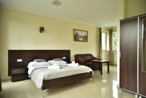 a bedroom with a large bed and a chair at Wodnik Turawa in Turawa