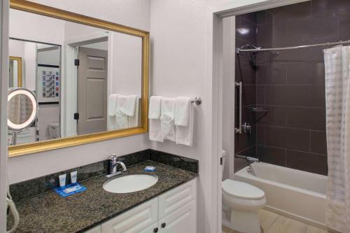 a bathroom with a sink and a toilet and a mirror at Hyatt House Parsippany East in Parsippany