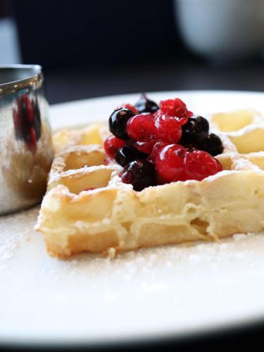 a waffle with berries on it on a plate at Doubletree by Hilton Edinburgh City Centre in Edinburgh