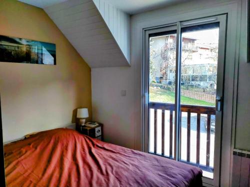 a bedroom with a bed and a large window at Appartement Guillestre 2 personnes in Guillestre