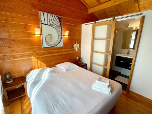 - une chambre avec un lit blanc et un lavabo dans l'établissement Welcoming chalet with nice garden and terrace, à Lège-Cap-Ferret