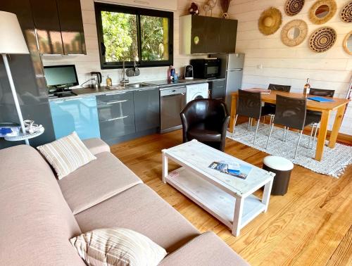 un salon avec un canapé et une table dans l'établissement Welcoming chalet with nice garden and terrace, à Lège-Cap-Ferret