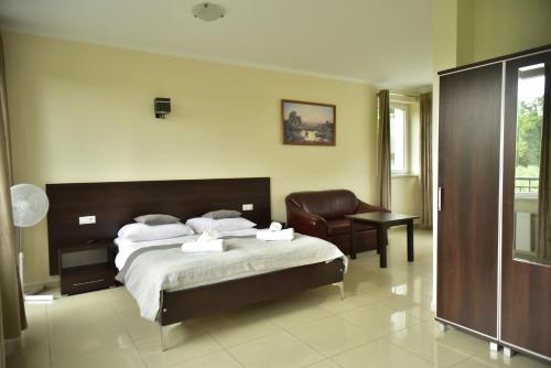 a hotel room with a bed and a chair at Wodnik Turawa in Turawa