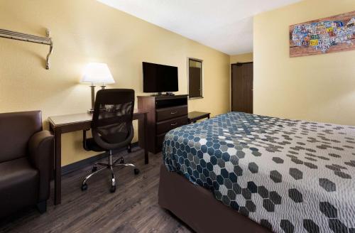 a hotel room with a bed and a desk and a chair at Econo Lodge Spotsylvania Town Center in Fredericksburg