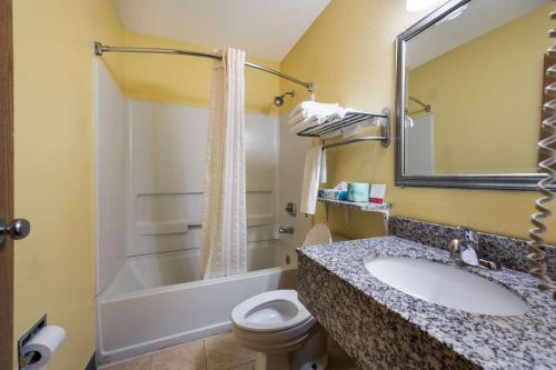 a bathroom with a sink and a toilet and a tub at Econo Lodge Spotsylvania Town Center in Fredericksburg