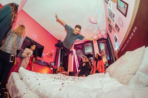 a man jumping in the air on a bed at Me and All Hotel Hanover, by Hyatt in Hannover