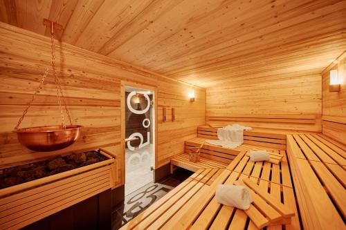 a wooden interior of a sauna with a bucket at Me and All Hotel Hanover, by Hyatt in Hannover