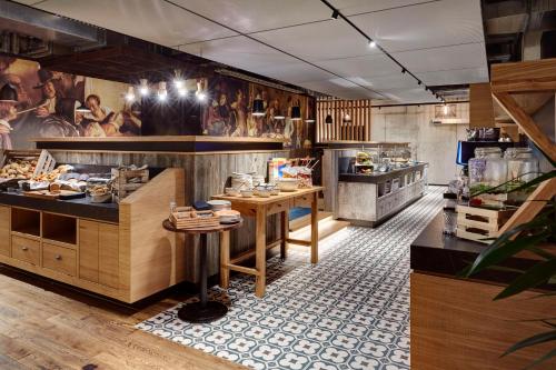 a restaurant with wooden counters and tables in a room at Me and All Hotel Mainz, by Hyatt in Mainz