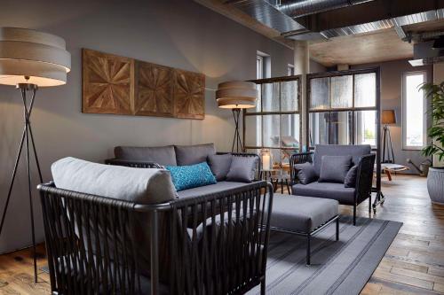 a living room with a couch and two chairs at Me and All Hotel Mainz, by Hyatt in Mainz