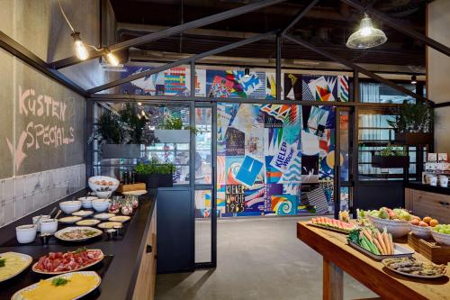 a restaurant with plates of food on a counter at Me and All Hotel Kiel, by Hyatt in Kiel