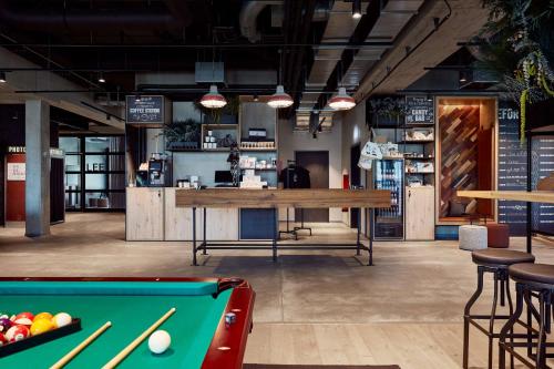 a billiard room with a pool table and a bar at Me and All Hotel Kiel, by Hyatt in Kiel