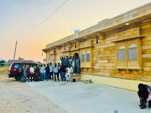 a group of people standing outside of a wooden building at Hotel Megha Haveli in Jaisalmer