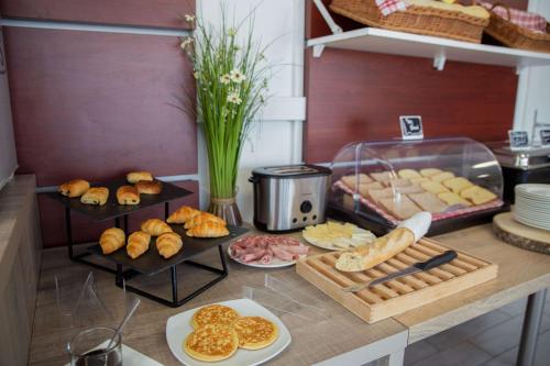 a counter with different types of bread and pastries at Comfort Aparthotel Cannes Mandelieu in Mandelieu-la-Napoule