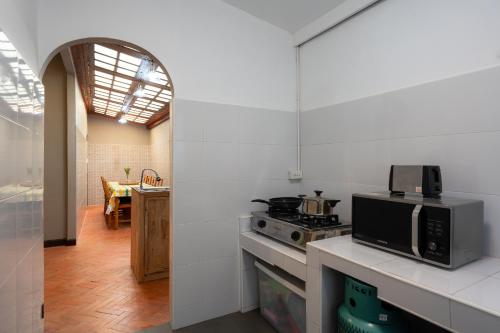 a kitchen with a stove and a microwave at Spacious Homey Pool Villa with Private Parking, Fenced Yard, BBQ, 5min to Beach, Pet-Friendly in Hua Hin