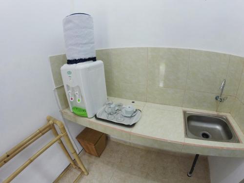 a bathroom with a sink and a roll of paper towels at Uluwatu Made Guesthouse in Uluwatu