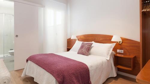 1 dormitorio con 1 cama con cabecero de madera en Hostal Oliva, en Barcelona