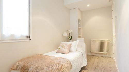 a white bedroom with a bed and a mirror at Hostal Oliva in Barcelona