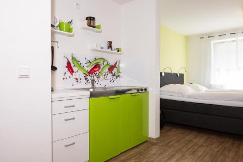 a kitchen with a green sink and a bed at Appartmentanlage/Ferienhaus Handewitt in Handewitt