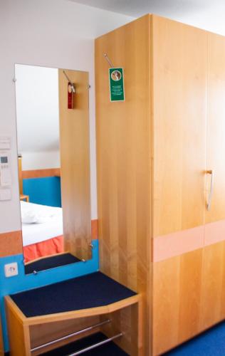 a dressing room with a mirror and a bed at Hotel-Restaurant Steuermann in Karlsruhe