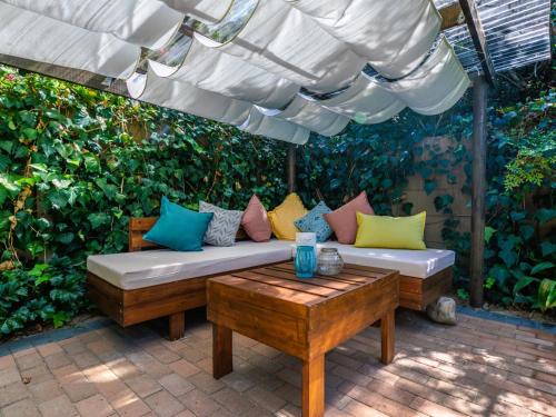 a patio with a couch and a table with pillows at Absolute Bosch Guest House in Stellenbosch