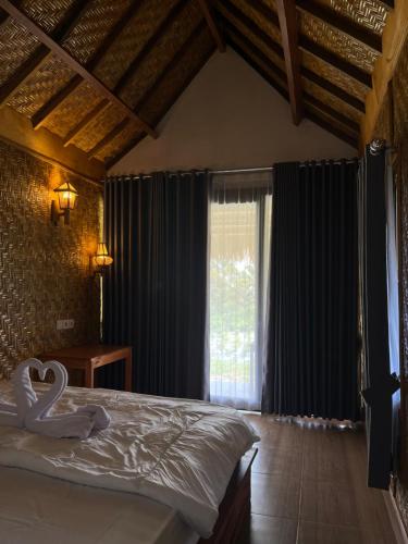 a bedroom with a bed with a swan decoration on it at PANORAMA BUNGALOWs in Tetebatu