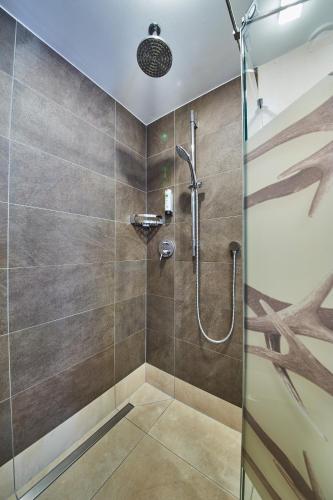 a bathroom with a shower with a glass door at Hotel DIE SONNE in Saalbach Hinterglemm