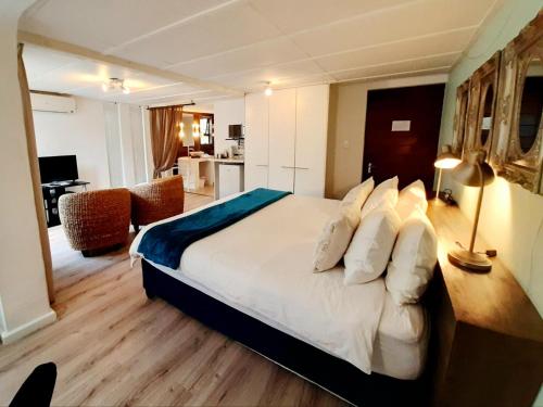 a bedroom with a large bed and a living room at Absolute Bosch Guest House in Stellenbosch