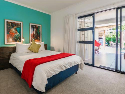 a bedroom with a bed and a sliding glass door at Absolute Bosch Guest House in Stellenbosch