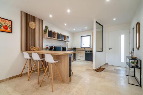a kitchen with a counter and stools in a room at Maison de charme avec Piscine-Clim-Plage à 10min in Fleury