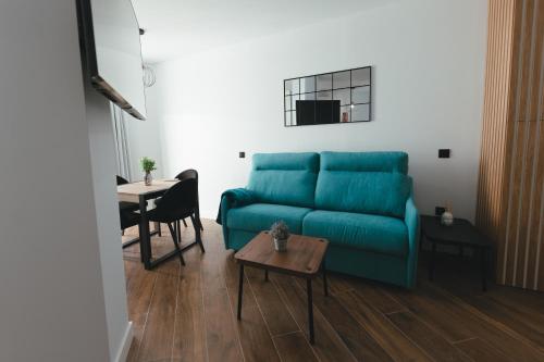 a living room with a blue couch and a table at Macarena Suites in Cáceres