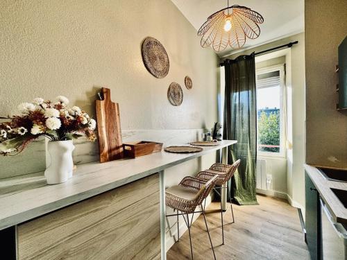 une cuisine avec un comptoir avec des chaises et un vase de fleurs dans l'établissement Le VeRdO, private garden, 400m Gare, à Rennes