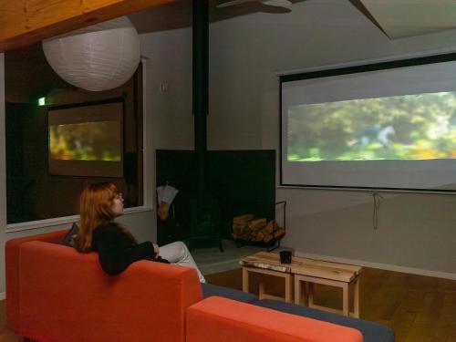 a woman sitting on a couch in front of a screen at BuenaVistaTokachi_碧 in Nishi-ihira