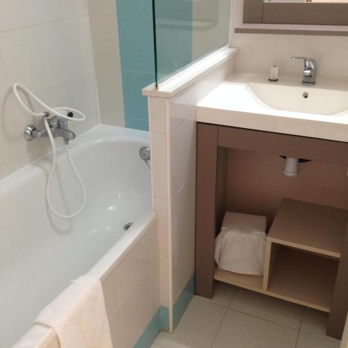 une salle de bain avec une baignoire et un lavabo dans l'établissement pierre et vacances, à Cannes