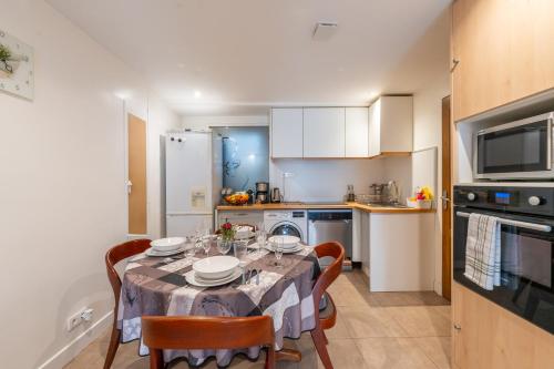 une cuisine avec une table et des chaises dans une cuisine dans l'établissement Les Coteaux 1 - Proche de Paris CDG, à Argenteuil