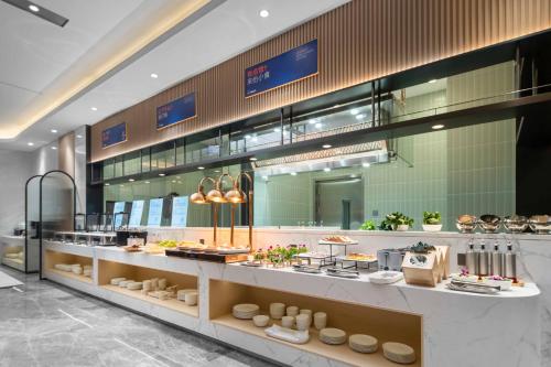 a restaurant with a buffet of food on display at Holiday Inn Express Harbin Central Avenue by IHG in Harbin