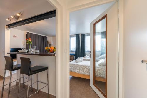 une chambre avec un lit et un miroir dans l'établissement Les Coteaux 3 - Studio à 10min de Paris, à Argenteuil