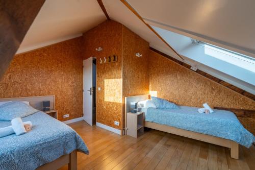 a bedroom with two beds in a attic at Les Coteaux 2 - 5 chambres proche CDG in Argenteuil