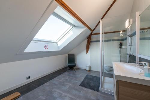 a bathroom with a sink and a skylight at Les Coteaux 2 - 5 chambres proche CDG in Argenteuil