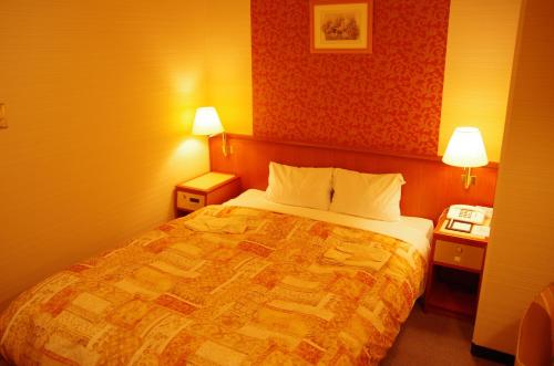 a hotel room with a bed and two night stands at Hotel Sunroute Goshogawara in Goshogawara