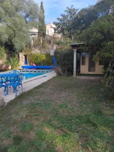 une cour avec une table bleue et une piscine dans l'établissement Villa tranquille à Montséret avec piscine privée, à Montséret