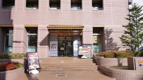 a building with a entrance with signs in front of it at U-Community Hotel in Osaka