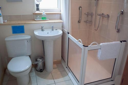 a bathroom with a sink and a toilet and a shower at Ornum Cottage in Beauly
