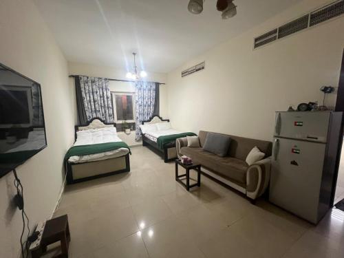 uma sala de estar com duas camas e um sofá em Smile Apartment Sharjah -FAMILY ONLY em Sharjah