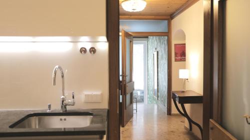a kitchen with a sink and a hallway at Thurners Dependance in Bruck an der Großglocknerstraße