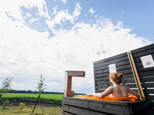a woman sitting in a wooden bath tub with at BuenaVistaTokachi_碧 in Nishi-ihira