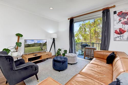 a living room with a couch and a television at Villa 2br Dolcetto Villa located within Cypress Lakes Resort in Pokolbin